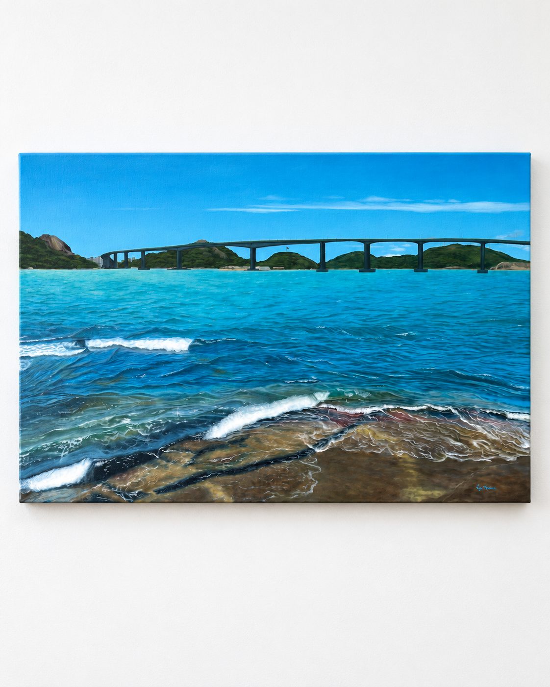 Mar azul e espuma sobre pedras, com ponte entre ilhas.